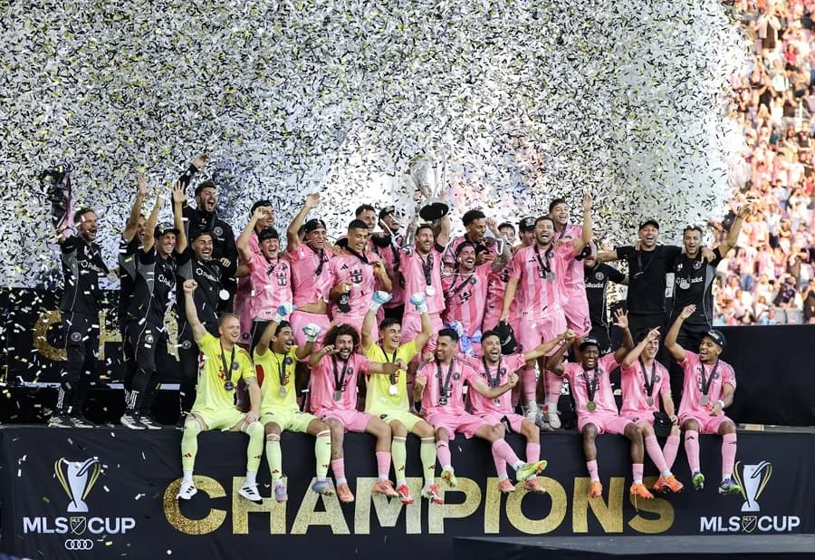 El legado de Lionel Messi ya estaba asegurado mucho antes de llegar al Inter Miami y unirse a la Major League Soccer (MLS). Había ganado una Copa del Mundo, decenas de trofeos y, en general, era considerado el mejor jugador en la historia del fútbol. No necesitaba una MLS Cup. Sin embargo, la quería, y la consiguió. Messi y el Inter Miami alcanzaron la cima, venciendo a los Vancouver Whitecaps 3-1 este sábado en la final de la MLS Cup, logrando el primer campeonato del club. Esto ocurrió dos años y medio después de la llegada de la leyenda al sur de Florida, un movimiento que sorprendió a muchos en su momento. “Decían que el fútbol nunca triunfaría en Estados Unidos”, dijo el comisionado de la MLS, Don Garber, durante la ceremonia de premiación. “Aficionados del Inter Miami, ¿ha triunfado el fútbol?” En el sur de Florida sí, gracias a Messi. Él asistió el gol que aseguró el título con un pase en el minuto 72 a Rodrigo De Paul, en una jugada donde Messi robó el balón y filtró un pase entre los defensores de Vancouver. De Paul la recibió en carrera, la mandó al rincón de la red y Messi saltó para abrazarlo unos segundos después, sonriente. Y mientras se agotaban los últimos minutos, los aficionados vestidos de rosa del Inter Miami —la mayoría con el número 10 de Messi en la espalda— se pusieron de pie y celebraron. El sur de Florida ya había visto títulos de la NFL, la NBA, la MLB y la NHL. Ahora también es una ciudad futbolera. Messi lo hizo posible. Tadeo Allende anotó en el minuto 6 del tiempo añadido —tras otra asistencia de Messi— para poner el 3-1. Y cuando Messi levantó el trofeo rodeado de sus compañeros, llovió confeti y estallaron fuegos artificiales. El Inter Miami se convirtió en la franquicia número 16 en la historia de la liga, de 30 años, en ganar un título de la MLS. Esto extiende una racha de paridad en la MLS, que ha visto a cinco franquicias diferentes ganar campeonatos en los últimos cinco años y a ocho franquicias reclamar un título en las últimas nueve temporadas; solo Columbus ha ganado dos veces en ese periodo. También fue la culminación de una odisea de 12 años para David Beckham, parte del grupo de propietarios del Inter Miami. Se retiró como jugador en 2013 y su contrato con la MLS le permitía iniciar una franquicia a tarifa reducida al terminar su carrera. Beckham eligió Miami y le tomó años hacerlo realidad; no fue hasta enero de 2018 cuando el club nació formalmente, tras asociarse con los empresarios Jorge Mas y Jose Mas, y aun así el equipo no tenía un estadio definido. El equipo comenzó a jugar en 2020, y Messi llegó a mitad de la temporada 2023. En ese momento, el Inter Miami estaba en el último lugar de la MLS. Y entonces llegó Messi. El equipo que era último, ahora lidera la liga. “Ha sido un viaje increíble”, dijo Beckham. El trofeo es el número 47 de Messi entre clubes y selección, extendiendo su récord global en el fútbol masculino, y algunos dicen que en realidad es el 48 porque la MLS otorga un trofeo por ganar el título de conferencia también. Ahora ha ganado al menos 21 títulos en finales a partido único, muchos de ellos con el núcleo de este equipo: Sergio Busquets, Jordi Alba, Luis Suárez y Javier Mascherano, sus compañeros de siempre en el Barcelona. Busquets y Alba se retiran y pudieron despedirse como campeones. El futuro de Suárez es incierto. Mascherano es ahora el entrenador, quien cambió la alineación y táctica del Inter Miami a mitad de temporada —su primera dirigiendo el club— con este momento en mente. Y el Messi de 38 años, el Jugador Más Valioso (MVP) de la MLS 2024 que parece seguro para ganar el premio otra vez esta temporada, sigue siendo único en los momentos más importantes y con un contrato que podría mantenerlo jugando en Miami hasta pasados los 40 años. Cuando comience la próxima temporada, el equipo jugará en un estadio nuevo cerca del Aeropuerto Internacional de Miami, con la mira puesta en un título consecutivo. “No está aquí solo para disfrutar de vivir en Miami”, dijo Beckham. “Su esposa y los niños aman Miami, pero él ha venido aquí para ganar, y de eso se trata realmente Leo. Quiere ganar. Tiene esa dedicación, la lealtad que muestra a sus compañeros, a la ciudad, al club. Leo es un ganador. Es así de simple”. Inter Miami se adelantó 1-0 con un autogol en el minuto ocho, antes de que Vancouver empatara en el minuto 60 con un gol de Ali Ahmed. Otro disparo de Vancouver pegó en ambos postes cerca de dos minutos después, pero no entró, y el Inter Miami recuperó la ventaja de forma definitiva cuando Messi encontró a De Paul. Y poco después del silbatazo final, Messi fue hacia la sección de aficionados del Inter Miami y levantó ambas manos en el aire. Fue un momento que se gestó durante dos años y medio.