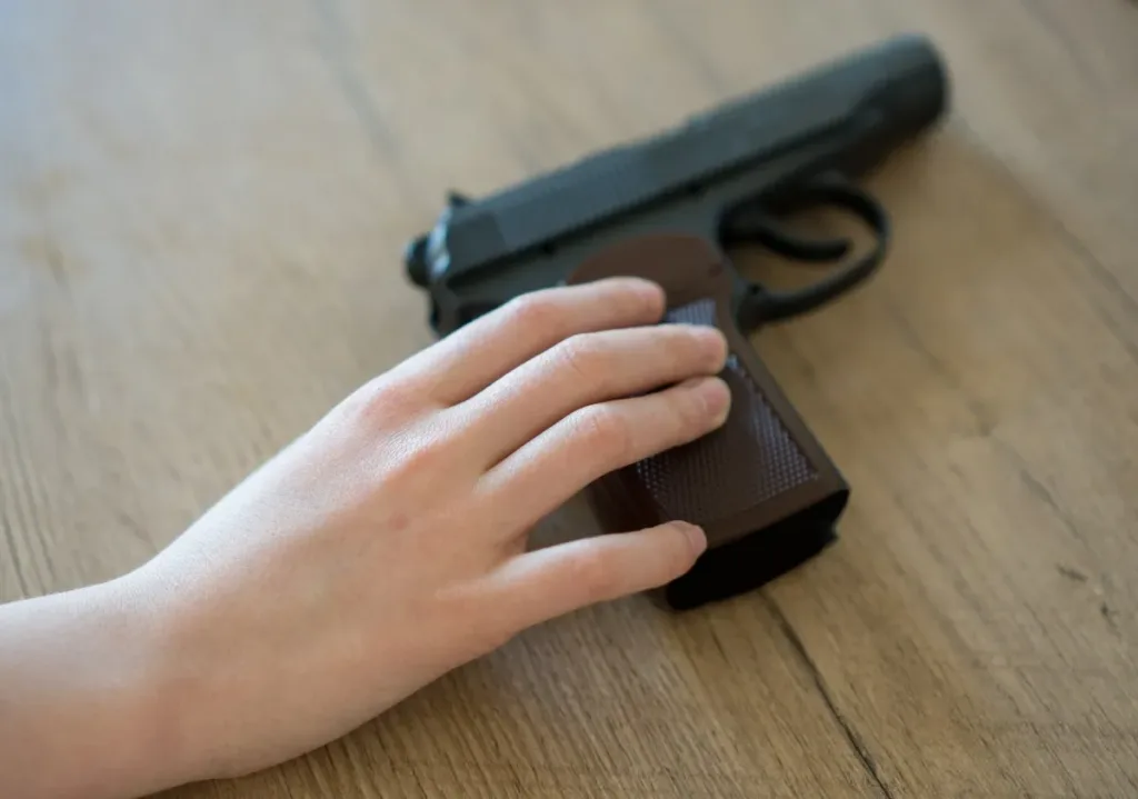 Arrestan a padre tras llevar niño arma cargada